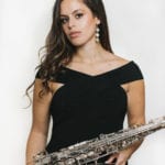 Alexa tarantino wearing black dress holding up alto sax
